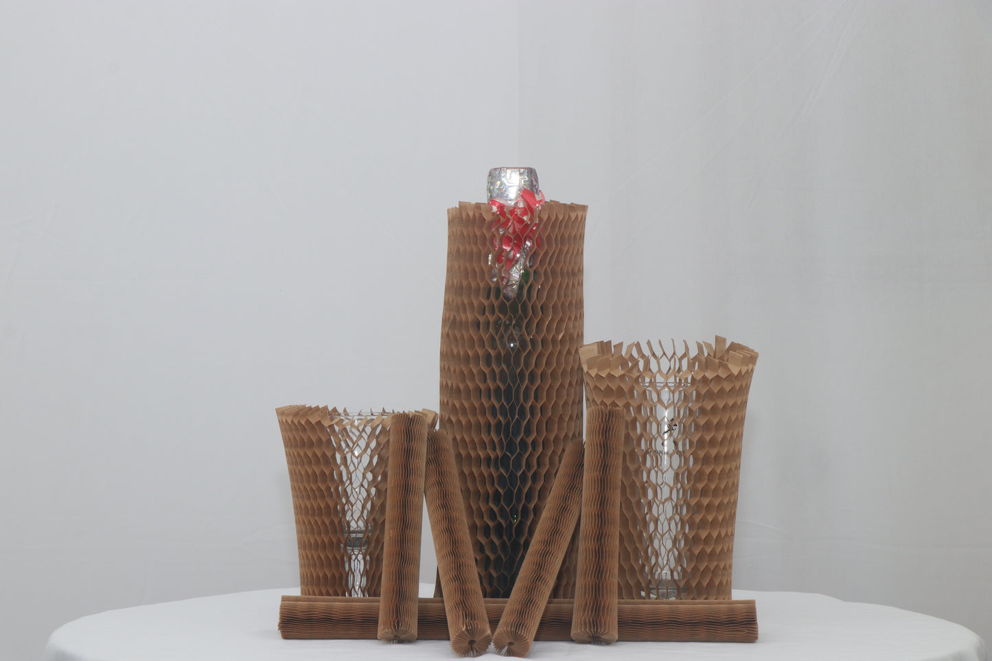 Set of brown textured vases on a white surface with a light gray background